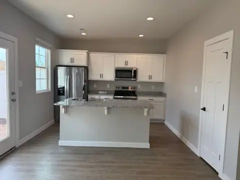 New white kitchen with island and stainless appliances